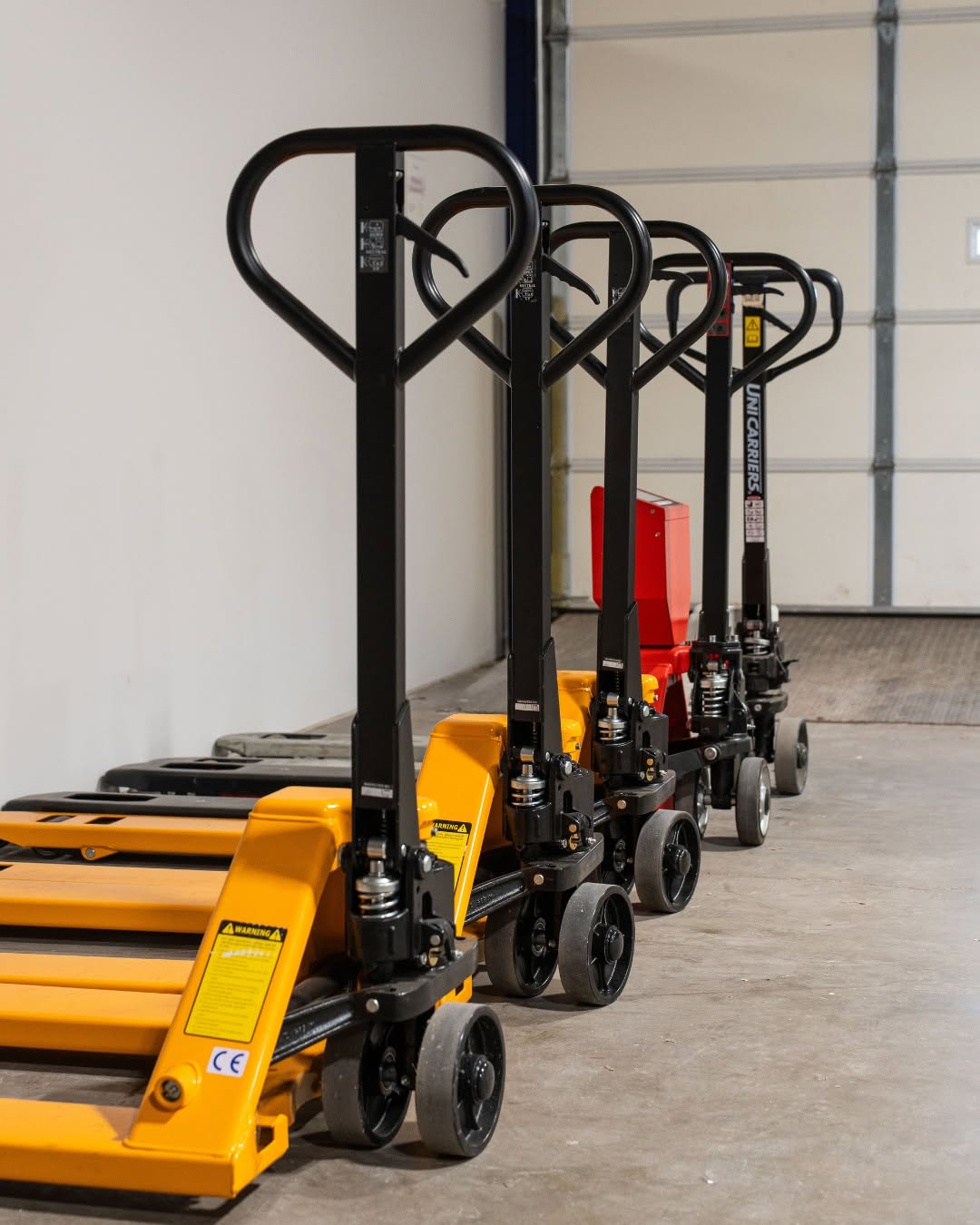 Row of pallet jacks lined up in a warehouse bay at Elevator's North Kansas City location, available for members to use
